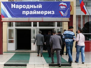 People enter a polling station before the start of the last round of United Russia party and All-Russian People's Front movement primaries ahead of December parliamentary election in Russia's Siberian city of Krasnoyarsk August 19, 2011. The banner reads, "People's primaries".  REUTERS/Ilya Naymushin  (RUSSIA - Tags: POLITICS ELECTIONS)