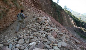 epa00549919 A news photographer climbs a small hill made up of landslides triggered by Saturday's earthquake on Srinagar-Muzaffarabad road near Jhandia, Uri, Tuesday 11 October, 2005. The town of Uri is one of the most affected areas by the 7,6 magniture earthquake which had hit parts of Pakistan, northern India and Afghanistan on 08 October. At least 40.000 people are feared killled by the earthquake so far.  EPA/ALTAF QADRI