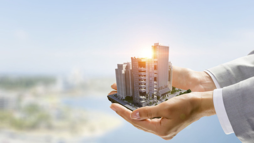 Close up of businesswoman hand holding construction model. Mixed media