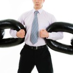 Powerful businessman holding sections of huge chain over white background