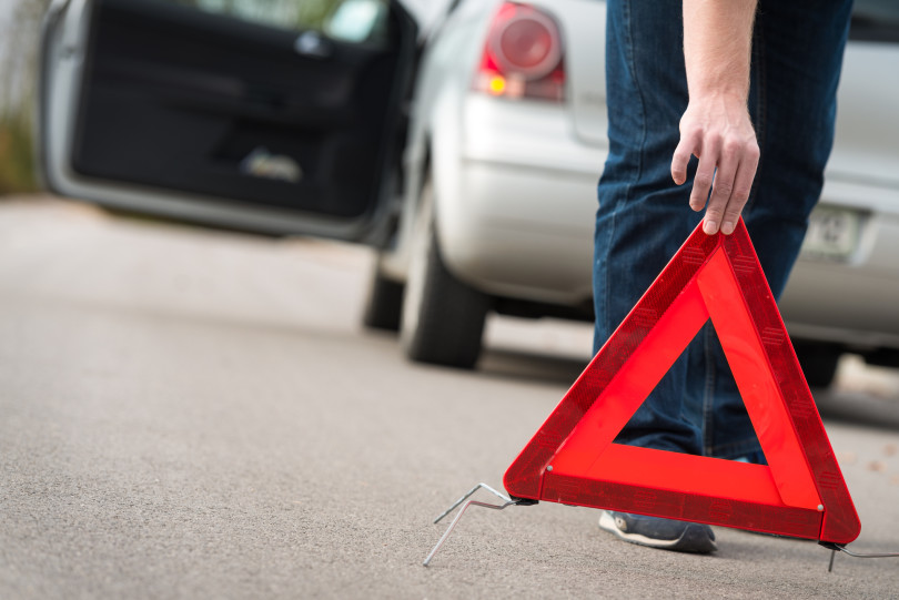 Man putting out warning triangle.